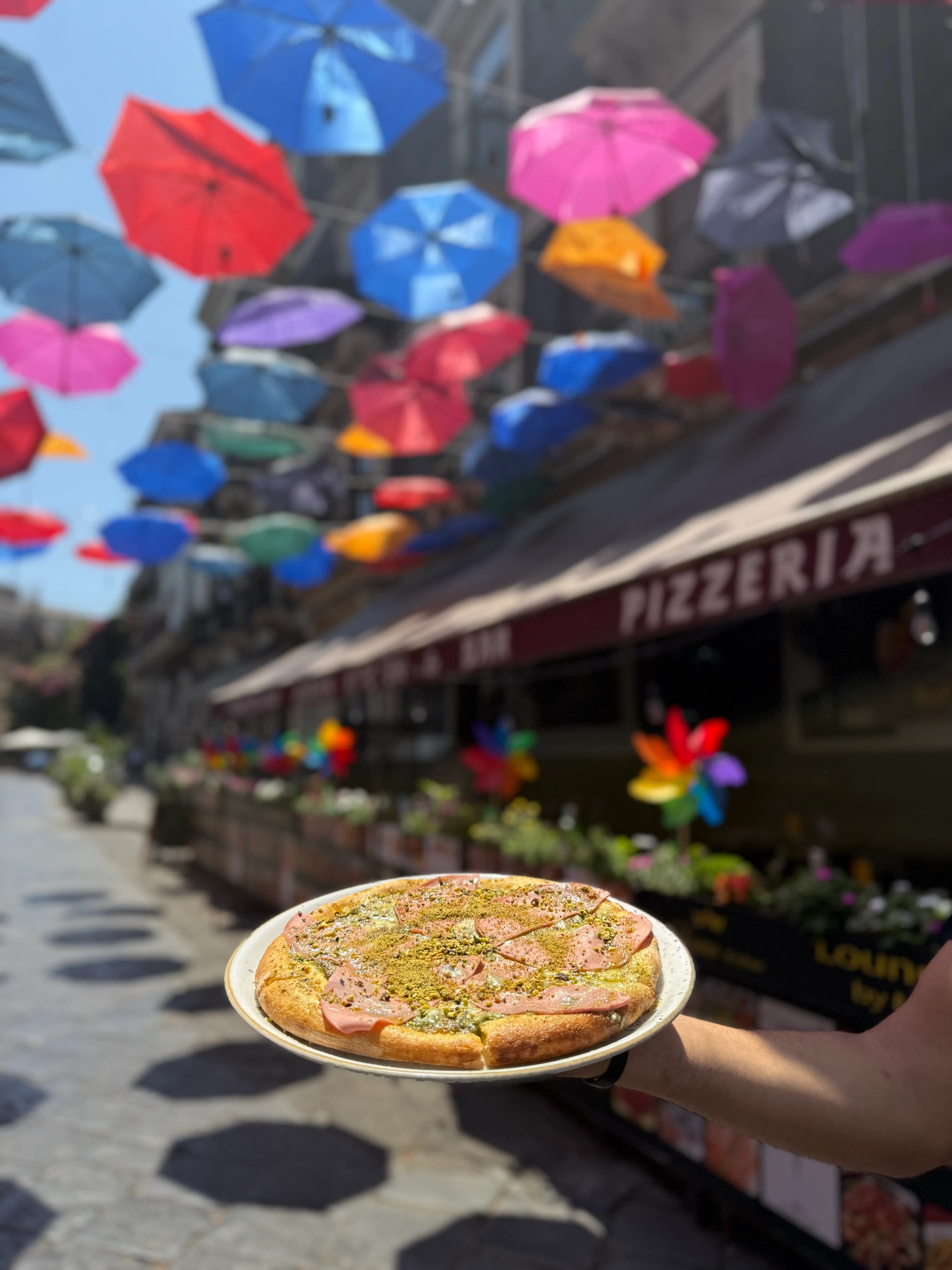 Pizza al pistacchio e mortadella di Heaven Kitchen & Bar, sotto gli ombrelli colorati del centro storico di Catania